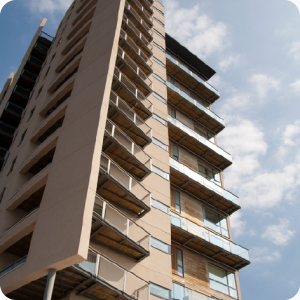 A concrete block of flats with a blue sky and white clouds in the background.