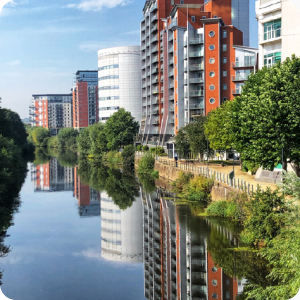 Several blocks of flats overlooking a canal with the reflection of the buildings in the water