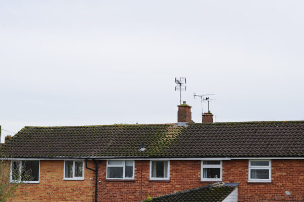Traditional English rooftops in a residential neighbourhood under cloudy skies